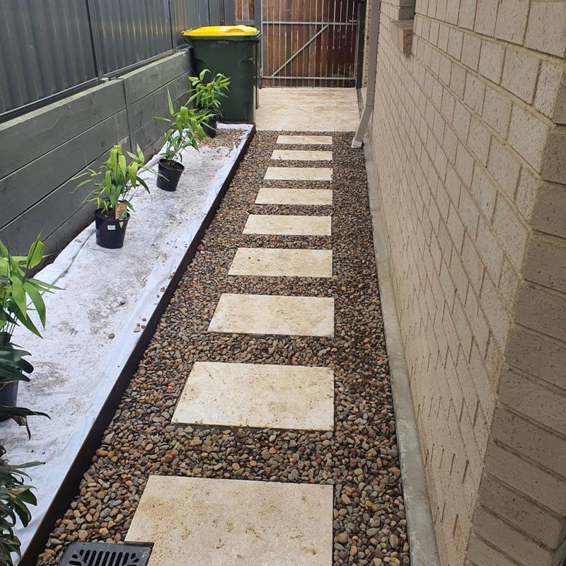A Stone Walkway With Potted Plants On The Side Of It — Green Envy Landscape & Garden Services In Cameron Park NSW