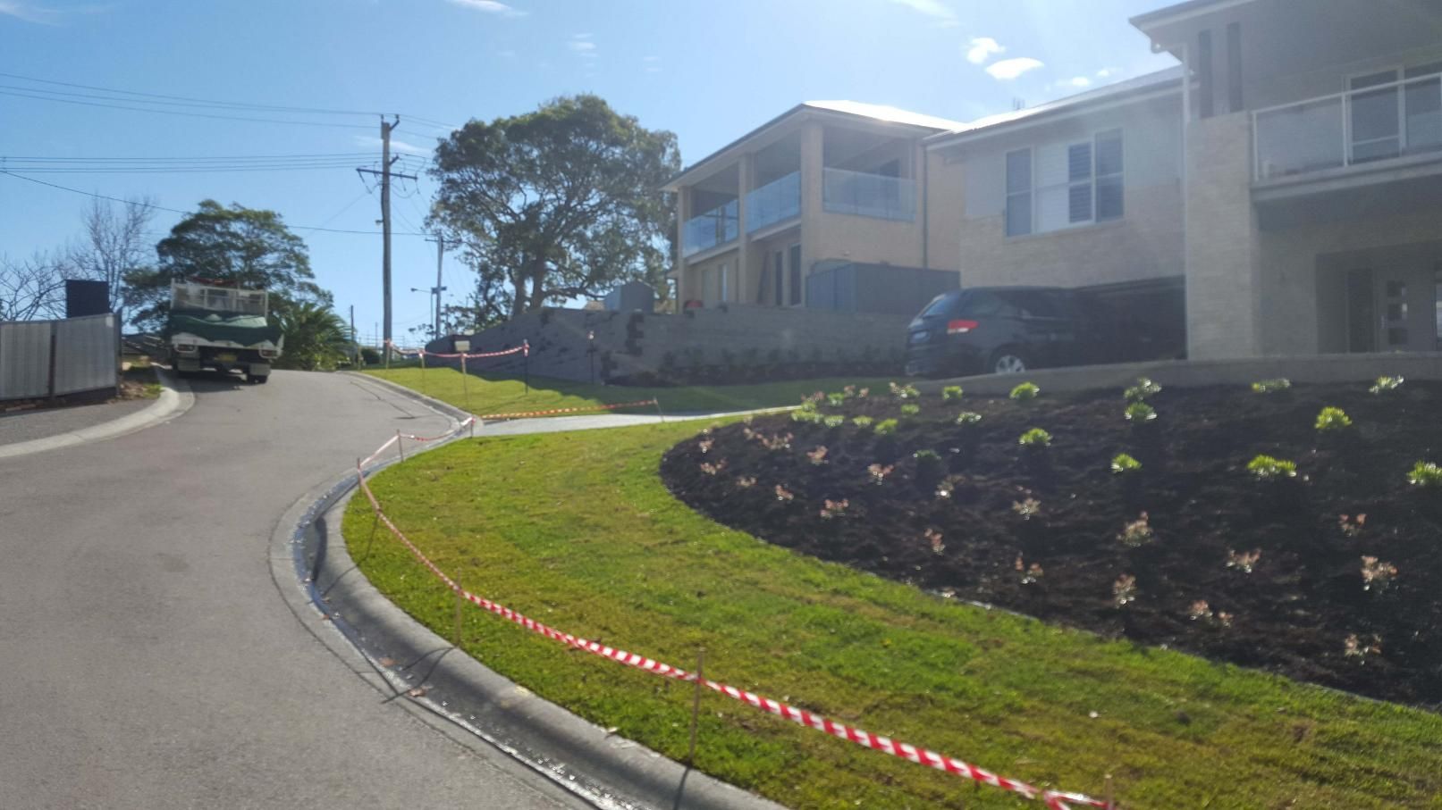 Curved Road Leading Uphill Past New Houses and Landscaped Gardens — Green Envy Landscape & Garden Services In Cameron Park NSW