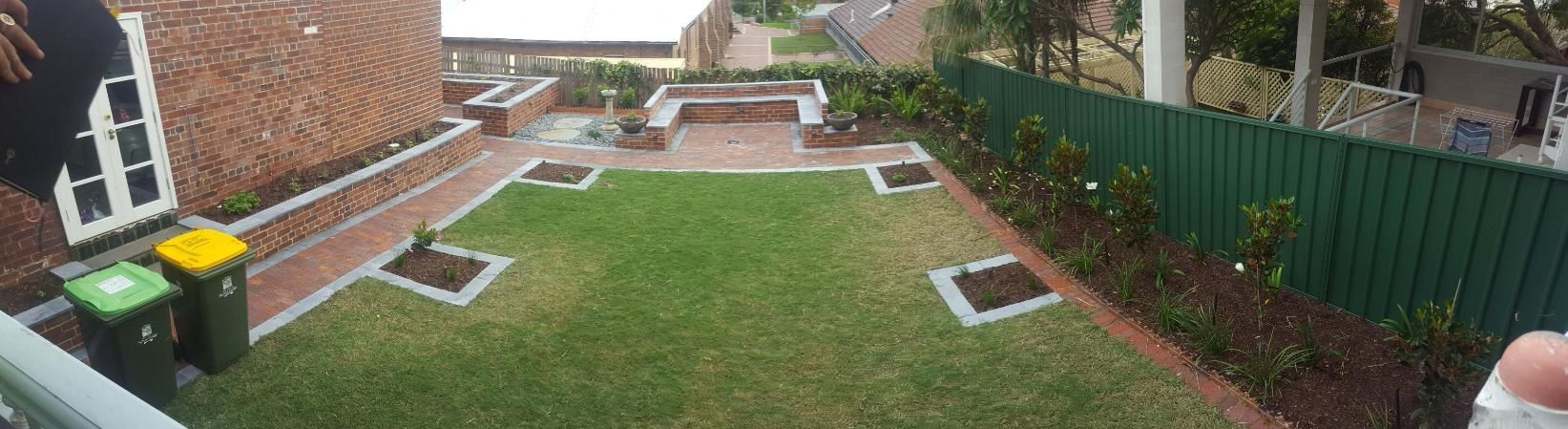 A Well-maintained Backyard With a Green Lawn, Brick Patio, and a Green Fence — Green Envy Landscape & Garden Services In Cameron Park NSW