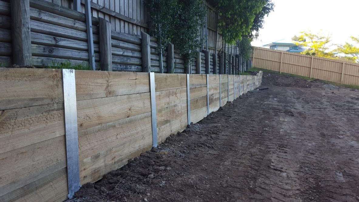 Wooden Retaining Wall Supported by Metal Strips — Green Envy Landscape & Garden Services In Cameron Park NSW