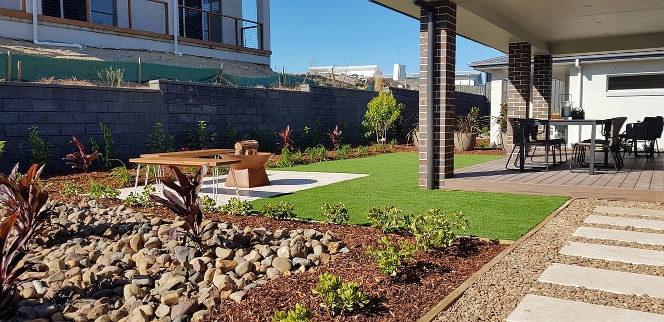 A Lawn Sprinkler Is Spraying Water On A Lush Green Lawn — Green Envy Landscape & Garden Services In Cameron Park NSW