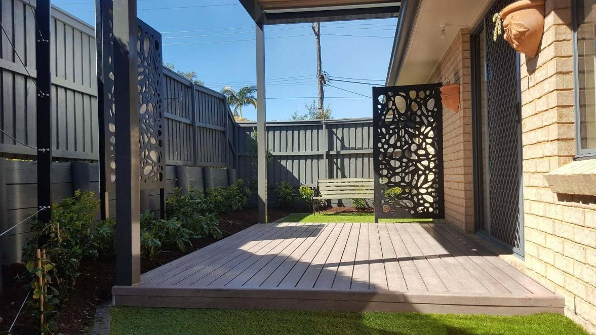 A Small Backyard Patio With Wooden Deck and Privacy Fencing — Green Envy Landscape & Garden Services In Cameron Park NSW