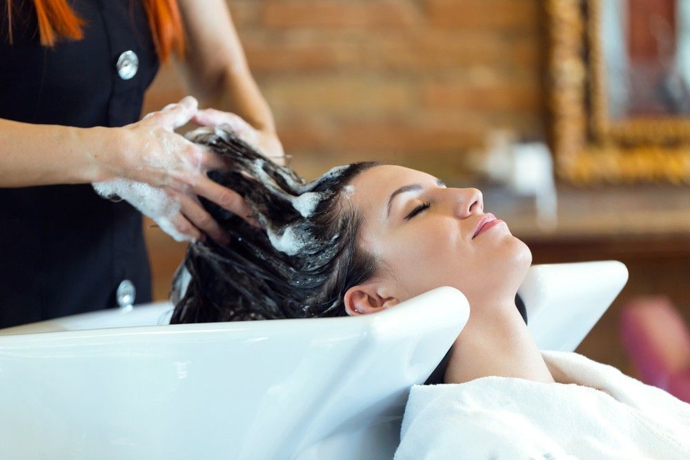 A Woman is Getting Her Hair Washed at a Hair Salon — AW Hair Studios - Surfers Paradise in Surfers Paradise, QLD