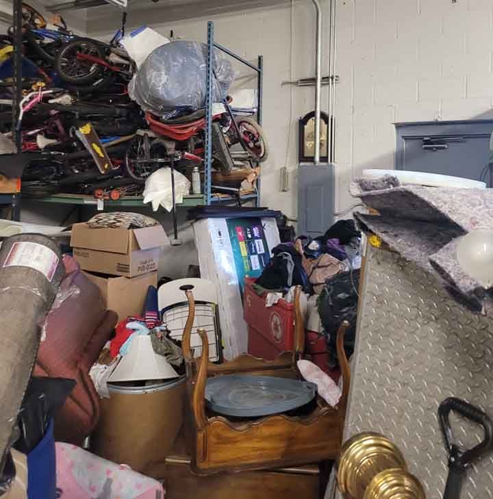 A room with a lot of papers on the floor and a shelf.