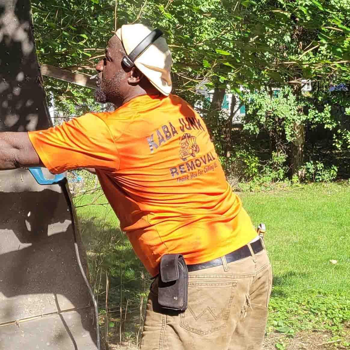 A man wearing an orange shirt that says baba junk removal