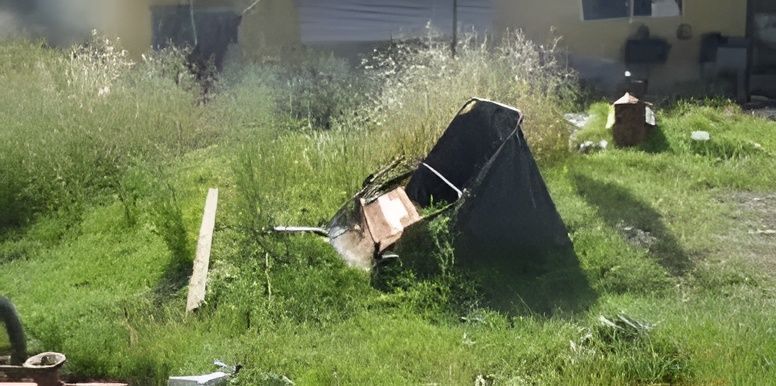 A tent is sitting in the grass in front of a house.