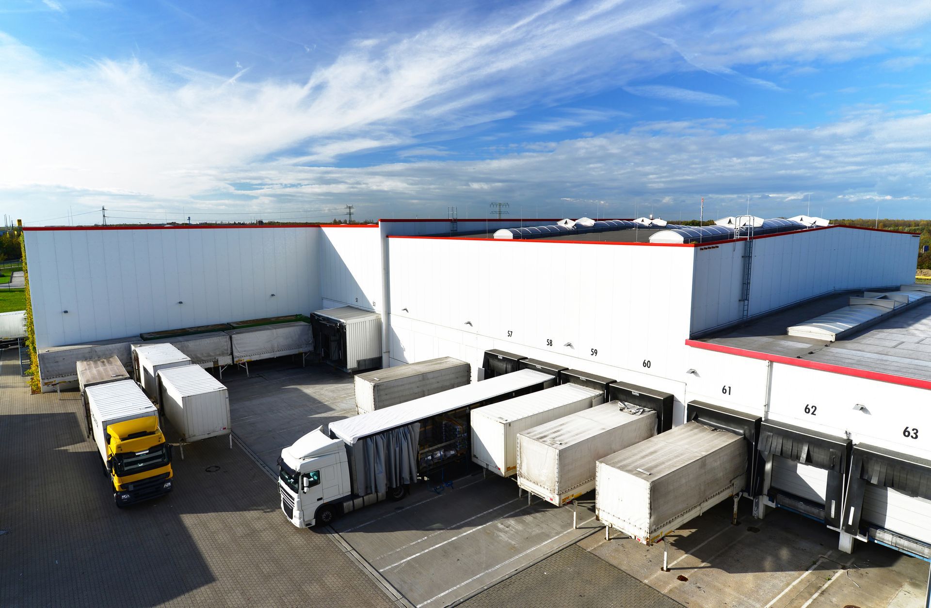 An aerial view of a warehouse filled with trucks and containers.