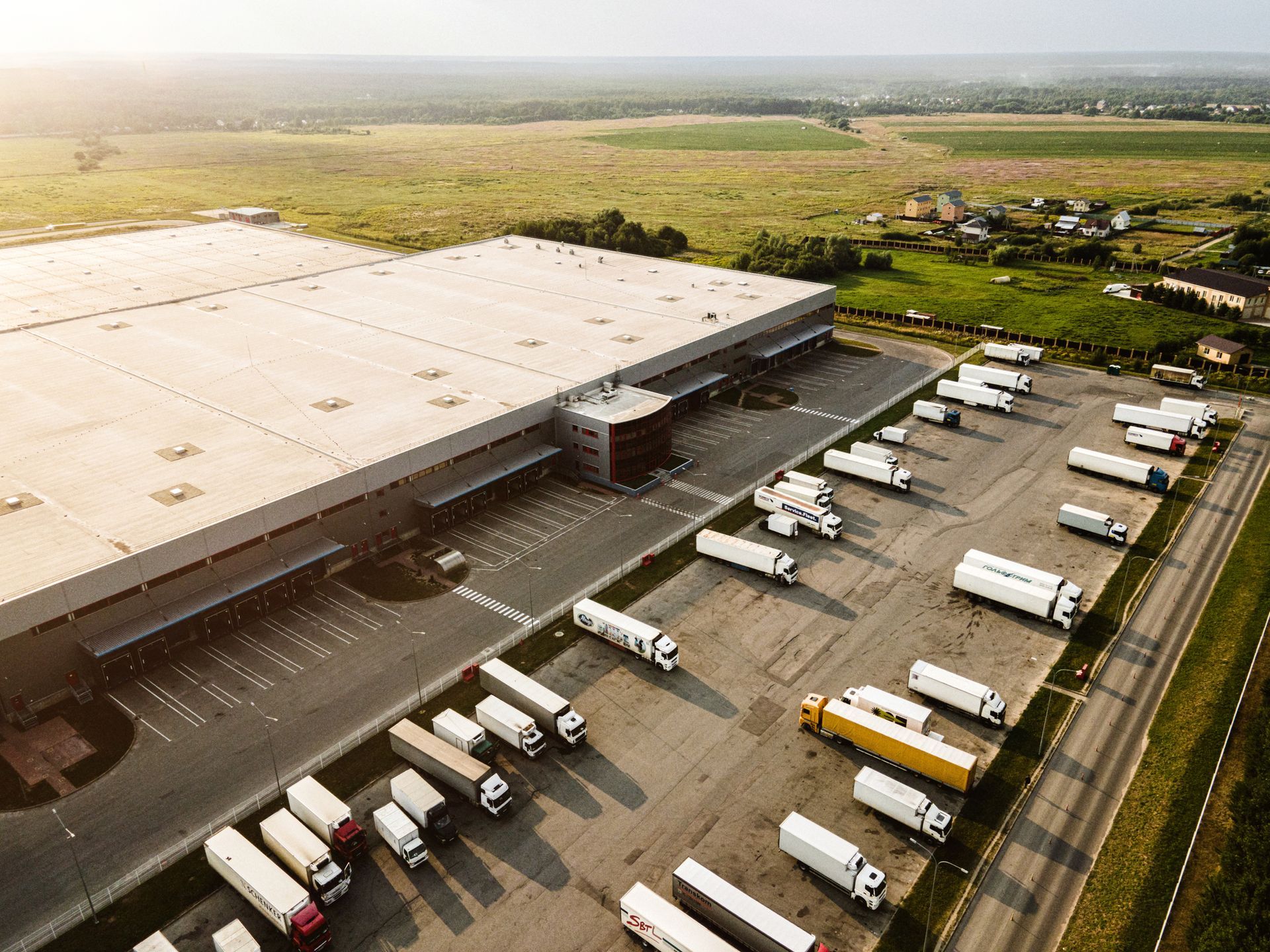 An aerial view of a warehouse with trucks parked in front of it.