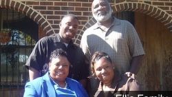 A group of people are posing for a picture in front of a brick building.