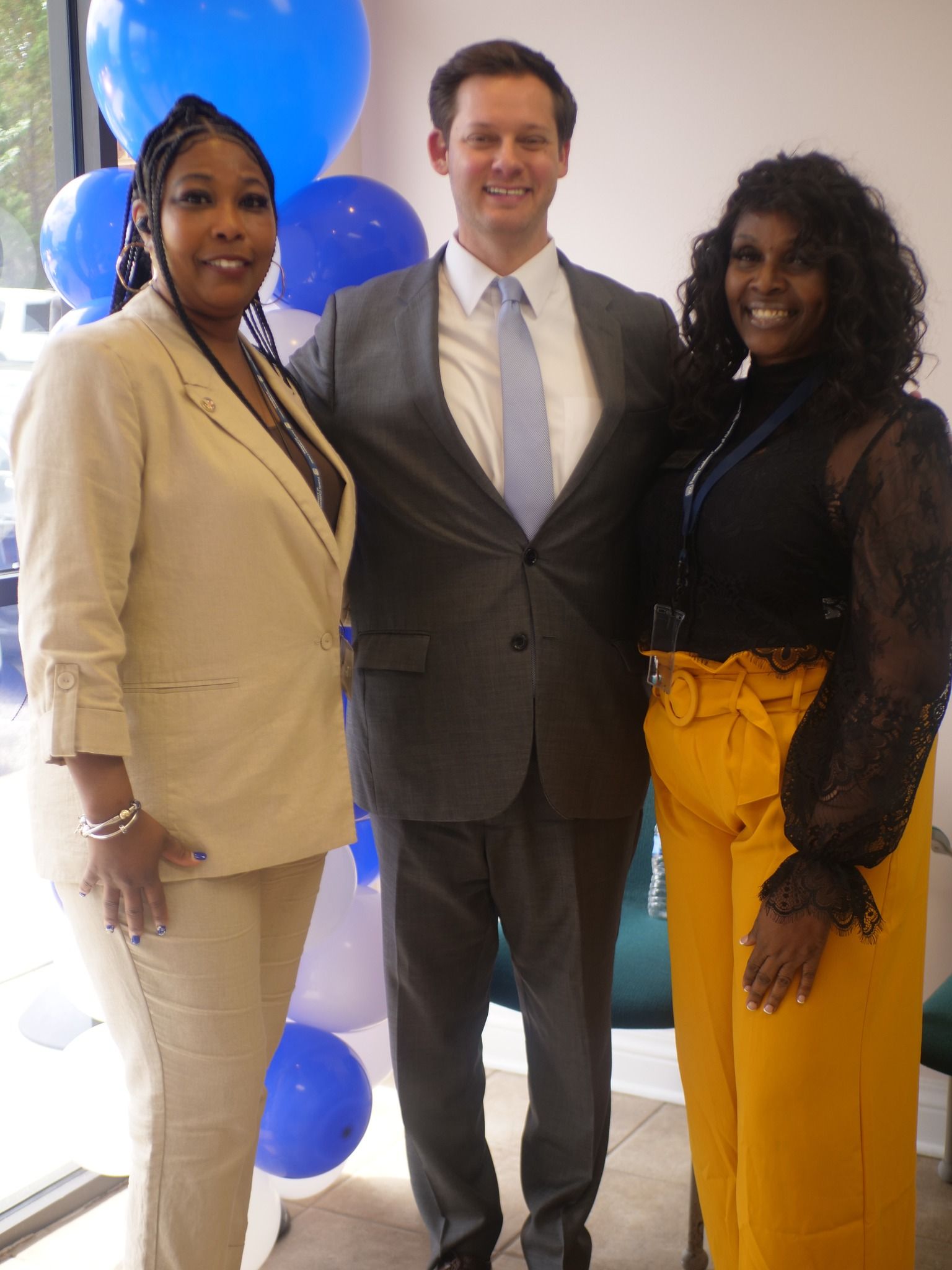 Three people are posing for a picture in front of a sign that says family guidance
