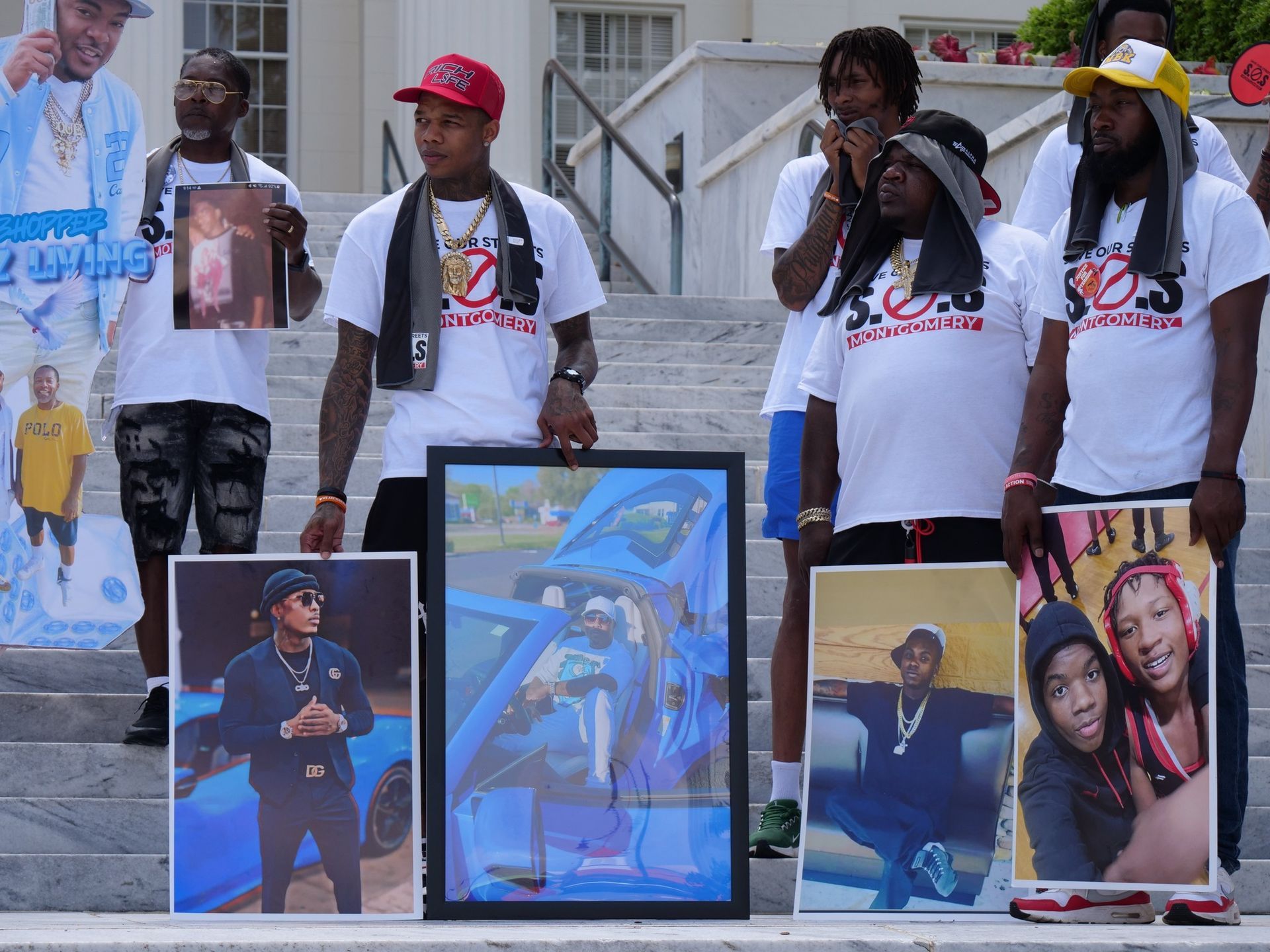 A group of men are holding pictures of their loved ones