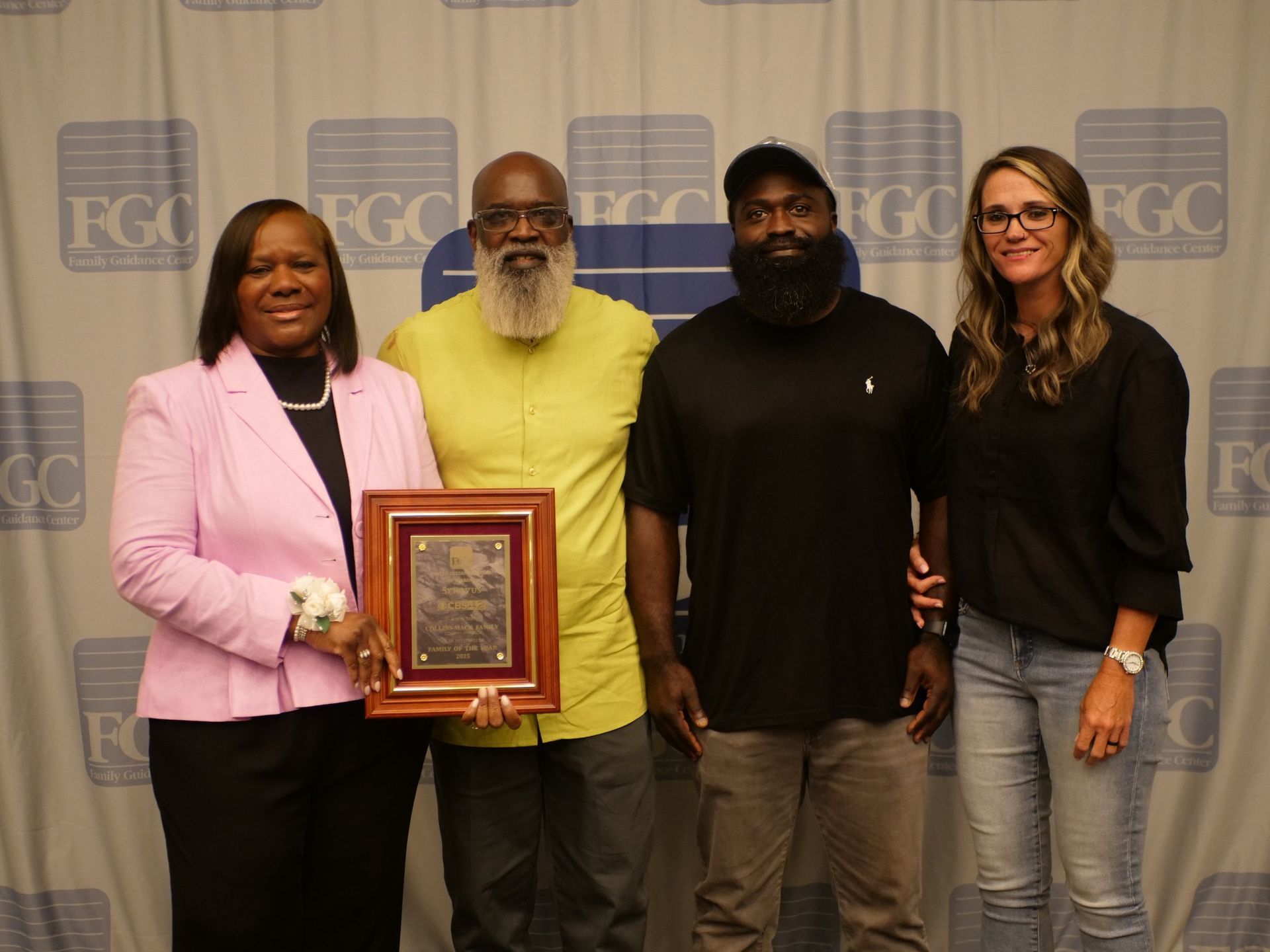 A group of people standing next to each other holding a plaque.