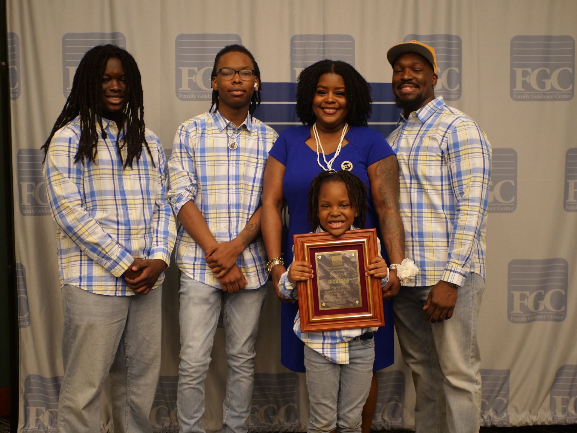 A group of people standing next to each other holding a picture frame.