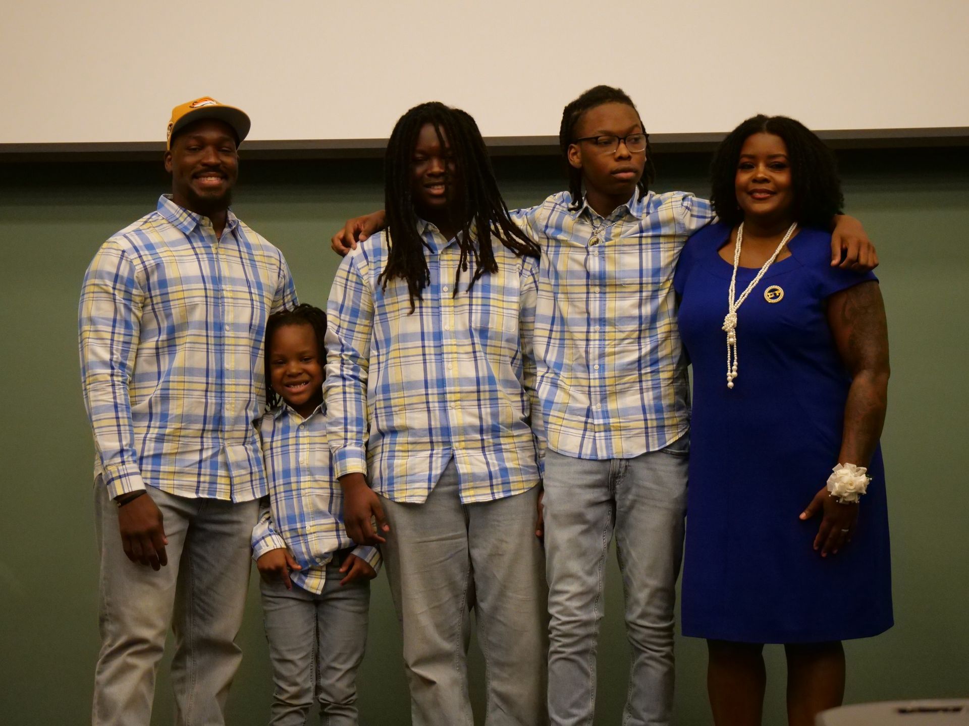 A group of people standing next to each other wearing plaid shirts.