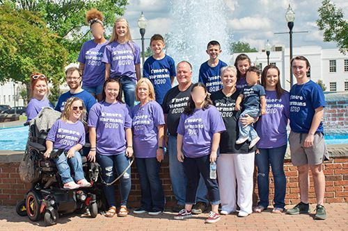 A large group of people are posing for a picture in front of a fountain.