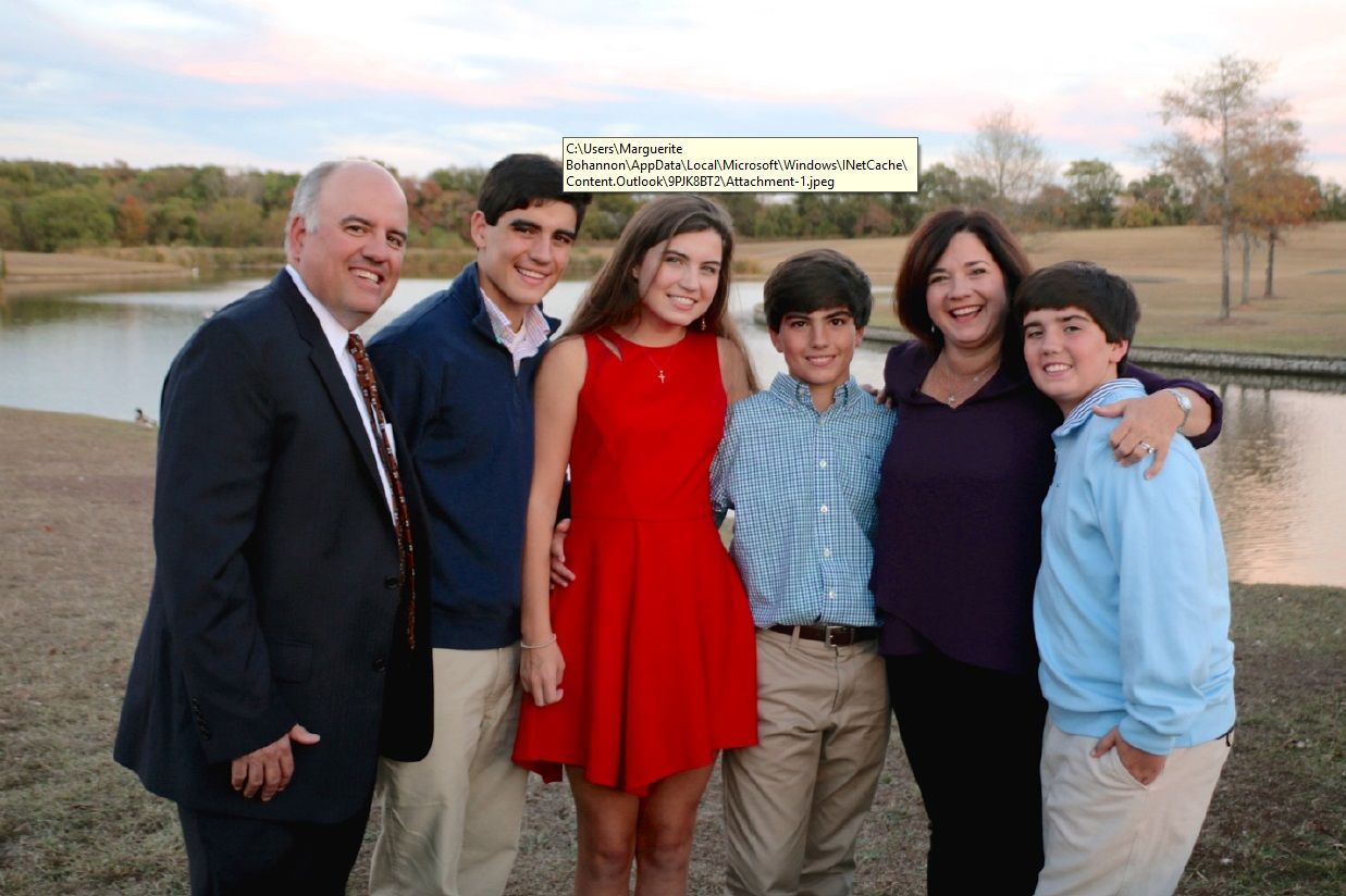 A family posing for a picture in front of a lake