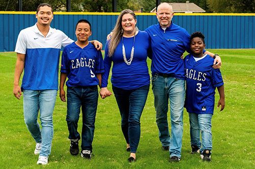 A group of people are standing next to each other on a baseball field.