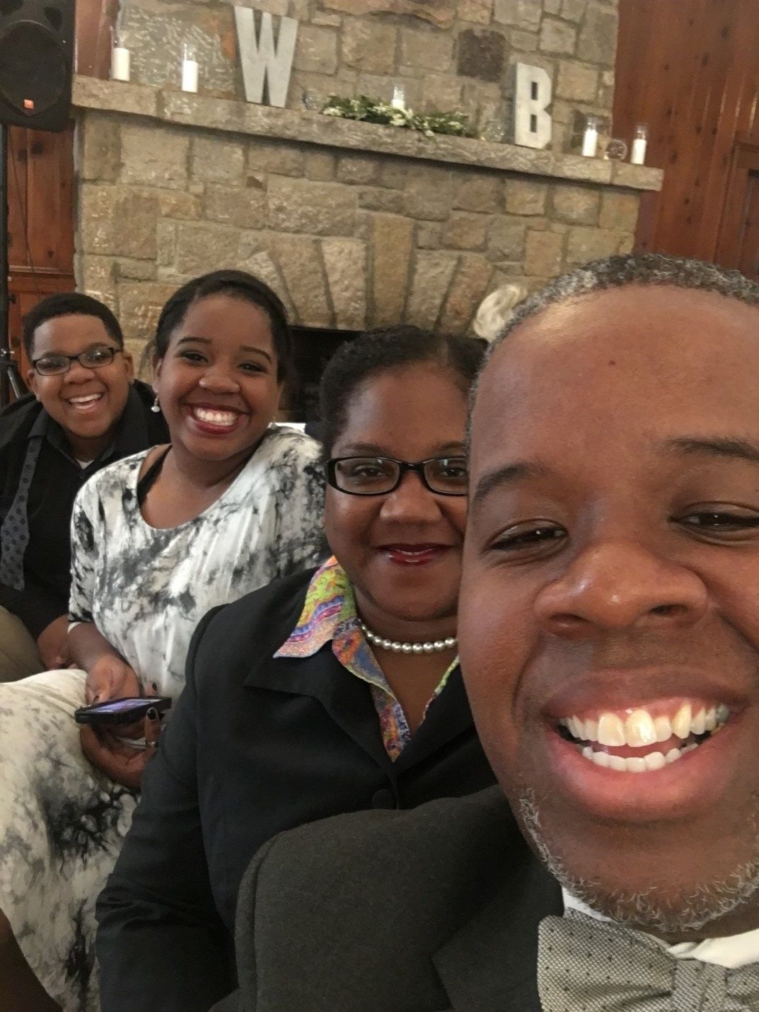 A group of people are posing for a picture in front of a fireplace.