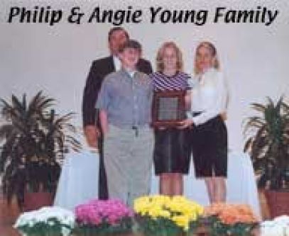A group of people standing next to each other in front of flowers.