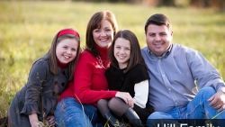 A family is posing for a picture in a field.