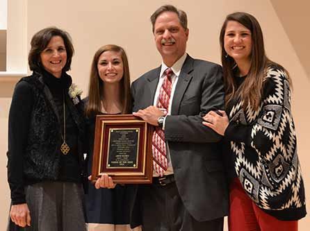 A group of people are standing next to each other holding a plaque.