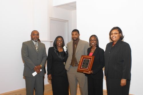 A group of people standing next to each other holding a plaque