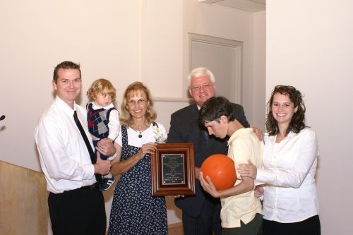 A group of people holding a plaque and a pumpkin