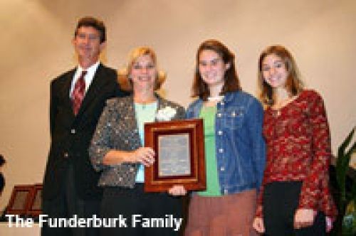 The funderburk family is holding a framed plaque