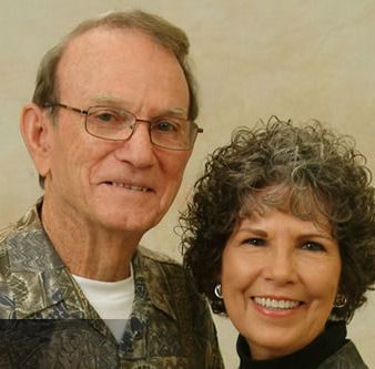 A man and woman are posing for a picture and smiling for the camera
