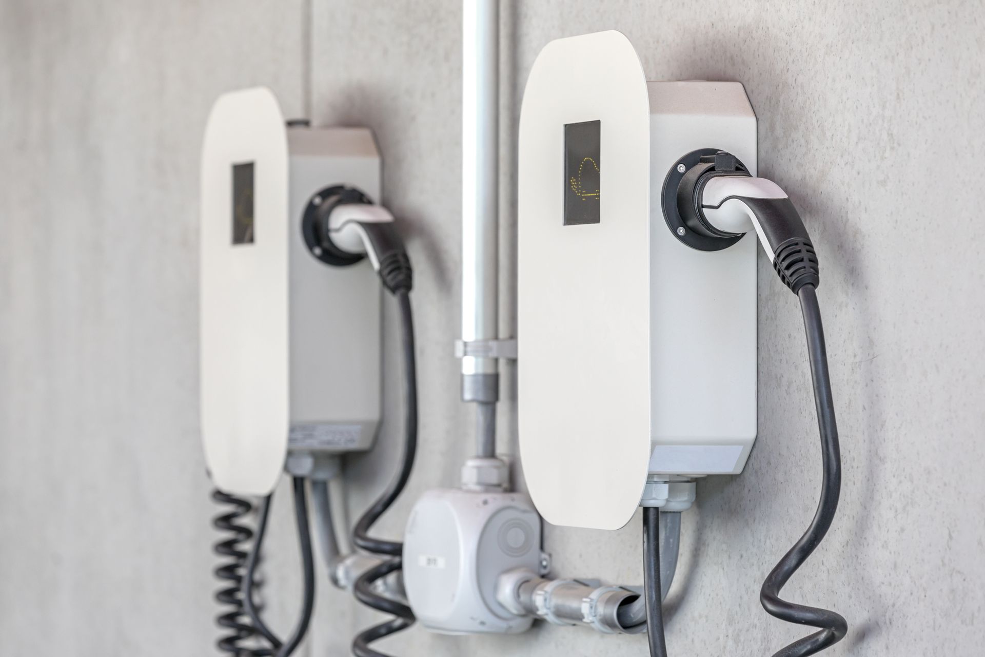 Tre stazioni di ricarica per auto elettriche sono collegate a una parete.