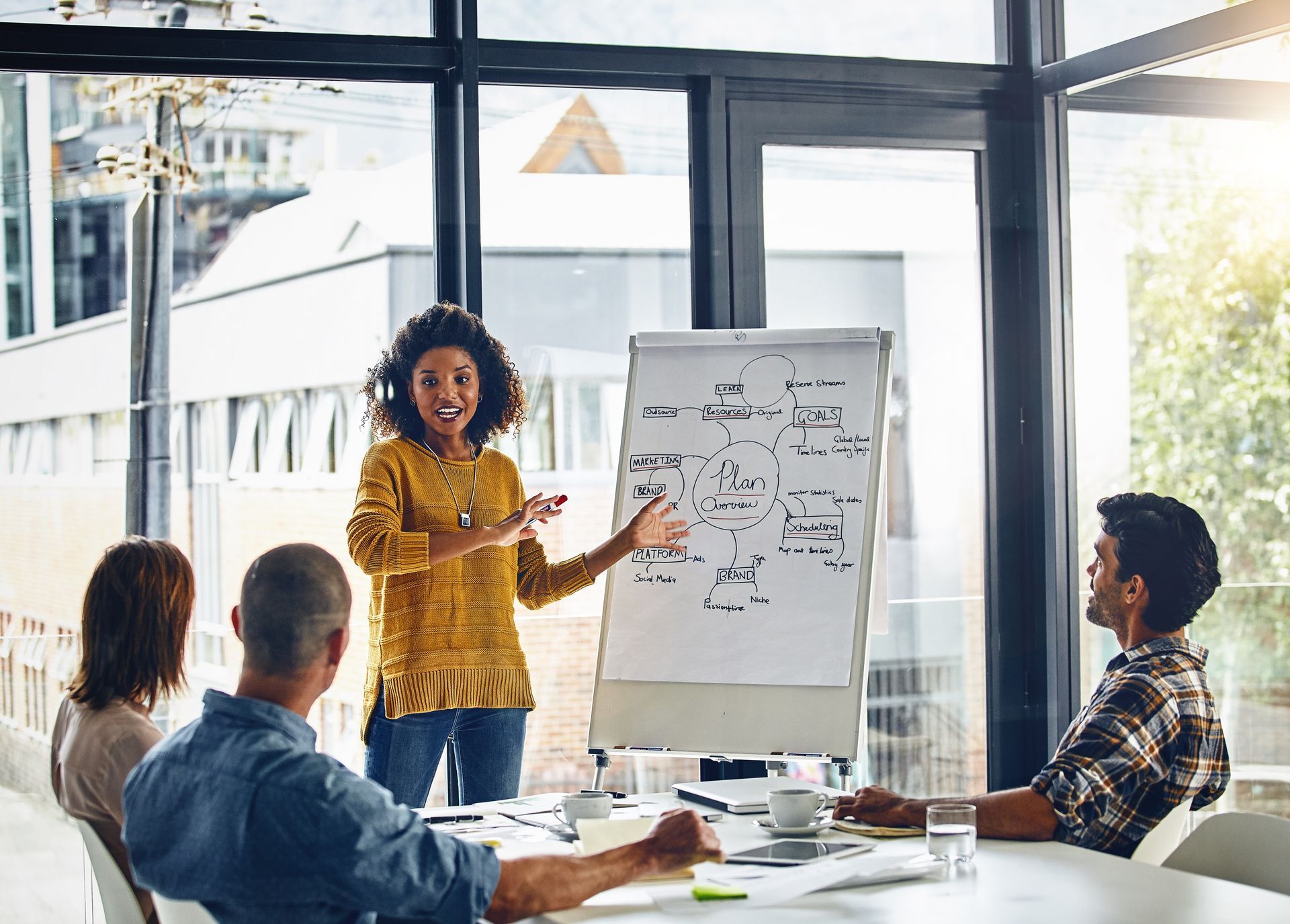 A woman is giving a presentation to a group of people in a conference room.