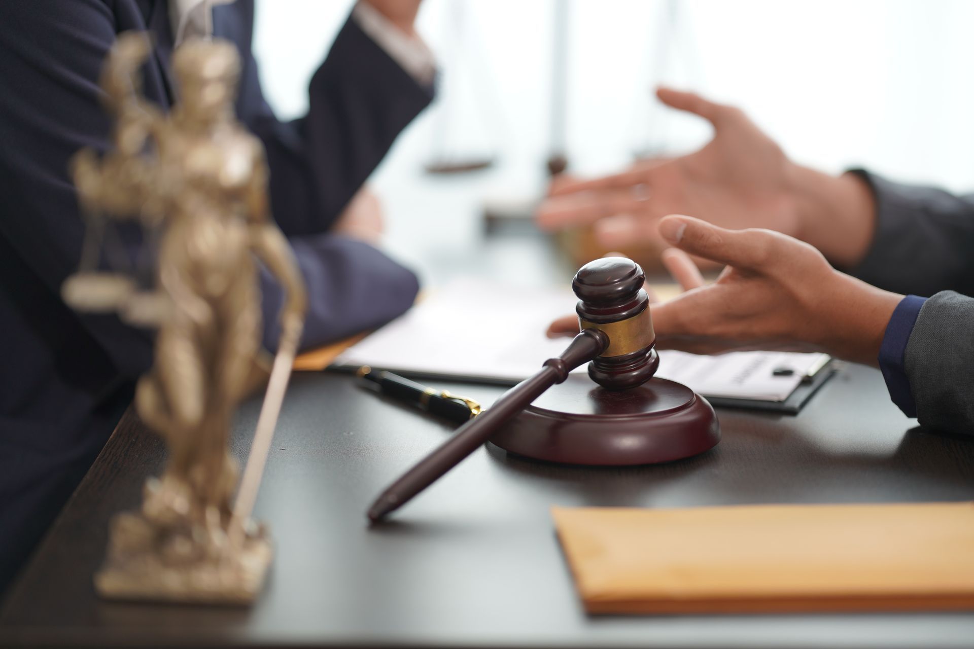 A statue of justice is sitting on a table next to a judge 's gavel.