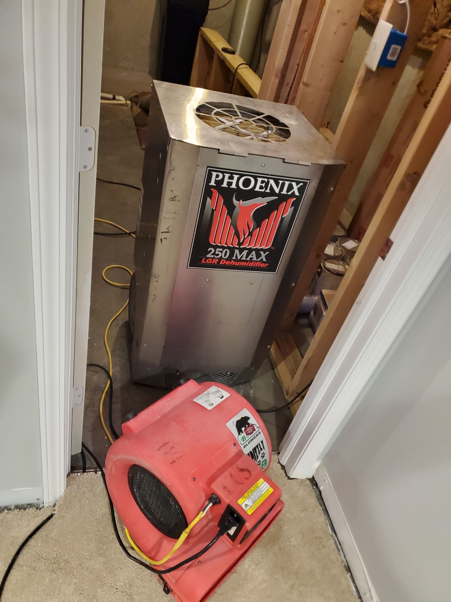 Large dehumidifier and blower in a room, likely for water damage remediation.
