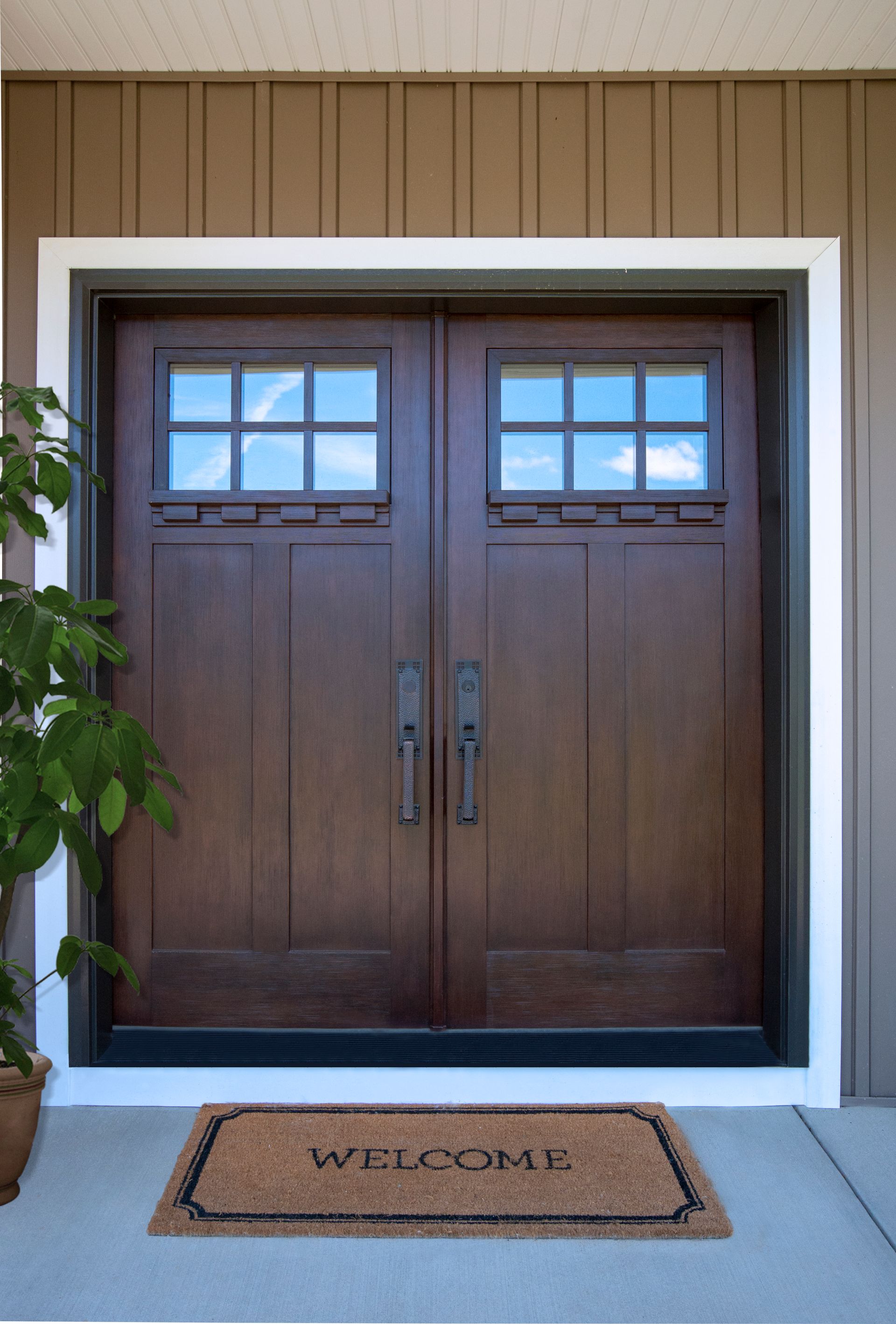 A dark wood double door with a six-pane window on each side, framed in white, with a