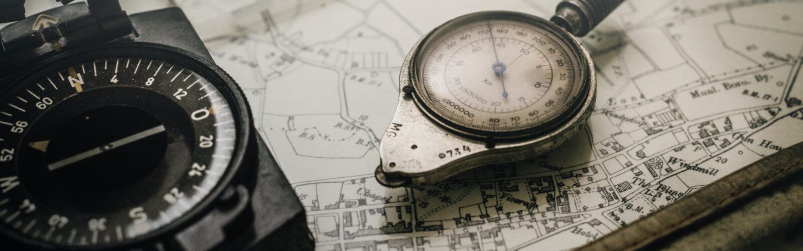 a compass and a watch are sitting on top of a map .