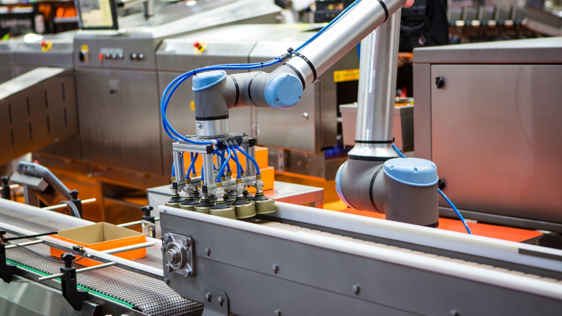 A robotic arm is working on a conveyor belt in a factory.