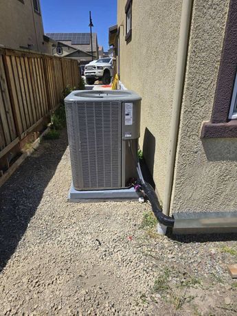 An air conditioner is sitting on the side of a house.