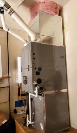 A large gray heater is sitting on top of a wooden table in a room.