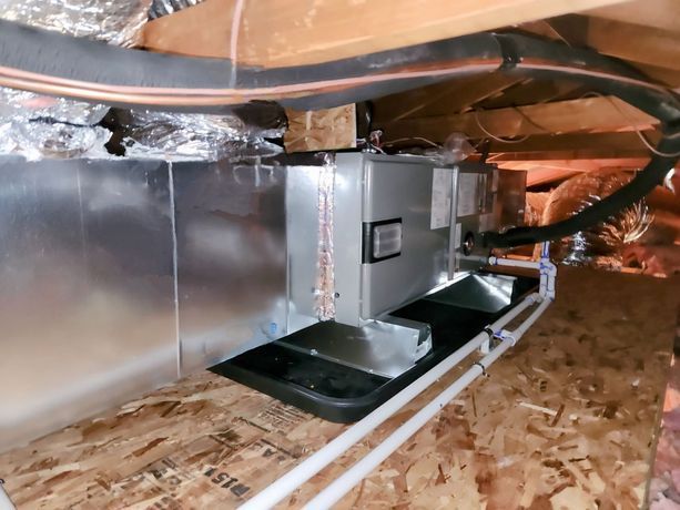 An air conditioner is installed in the attic of a house