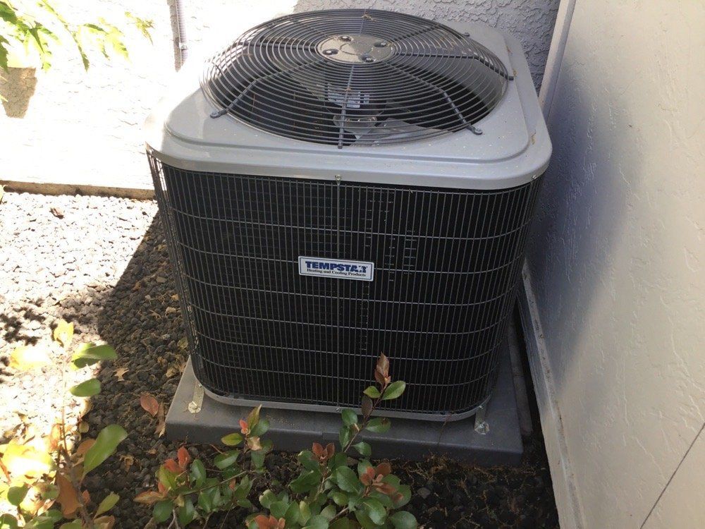 An air conditioner is sitting on the side of a building