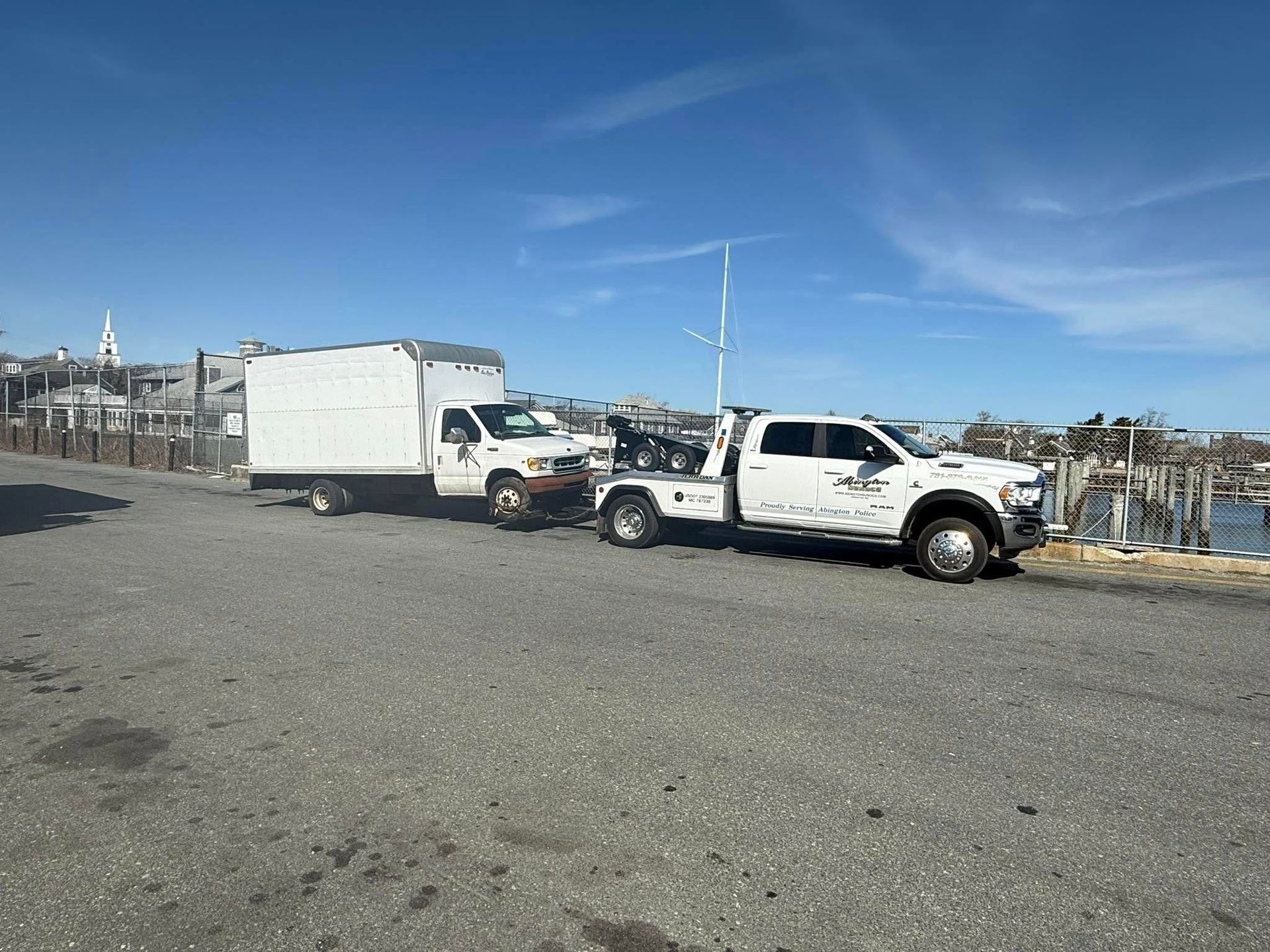 Two tow trucks are parked next to each other in a parking lot.