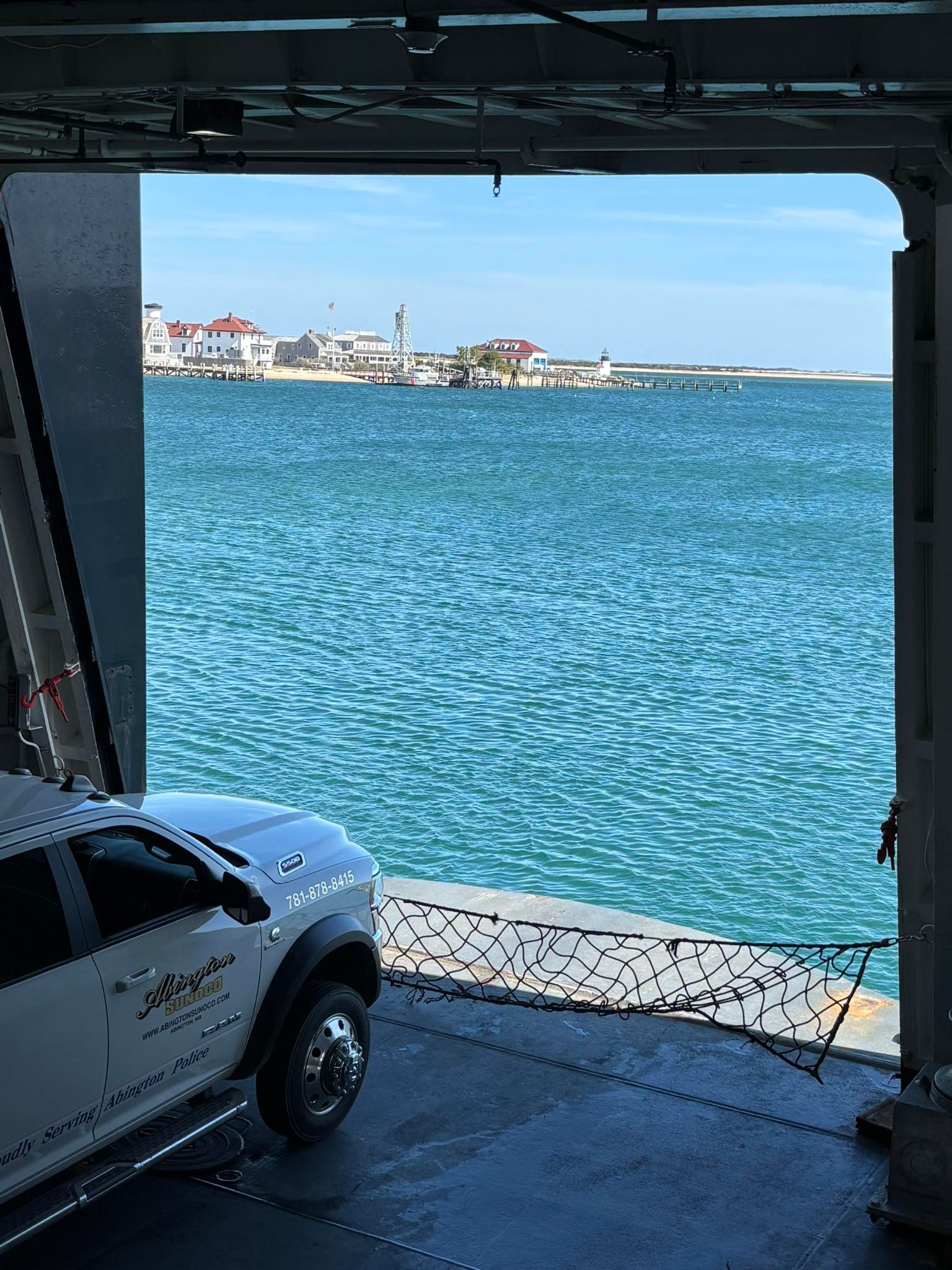 A car is parked in front of a large body of water.