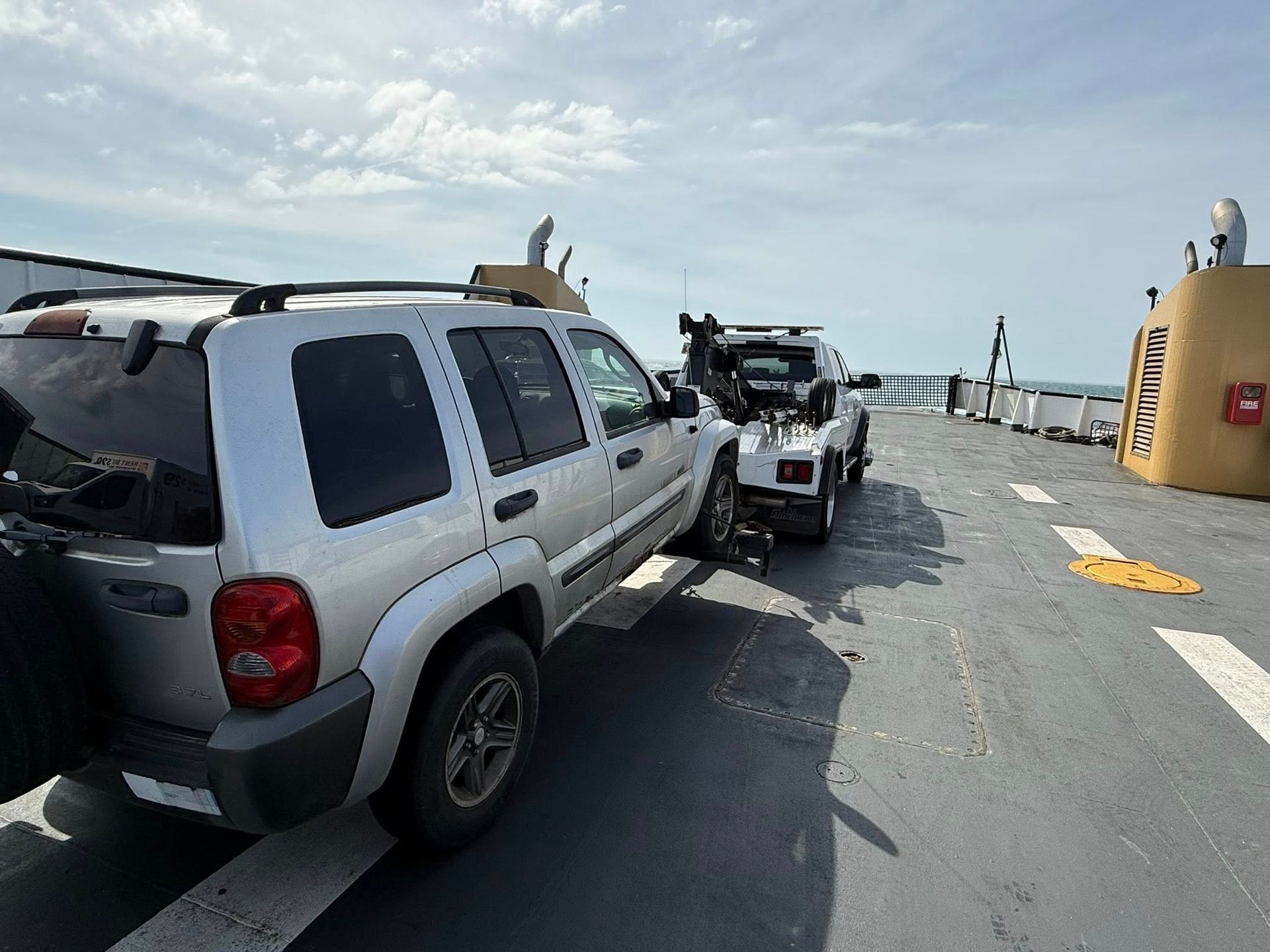 A jeep is being towed by a tow truck