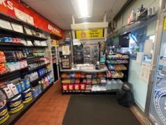 A convenience store with lots of shelves and a counter.