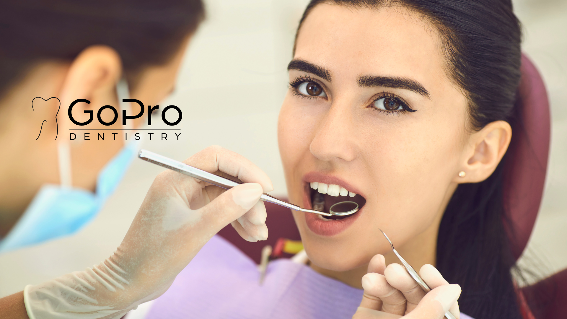 A woman is getting her teeth examined by a dentist.