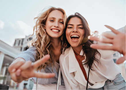 Two women are making a peace sign with their hands.