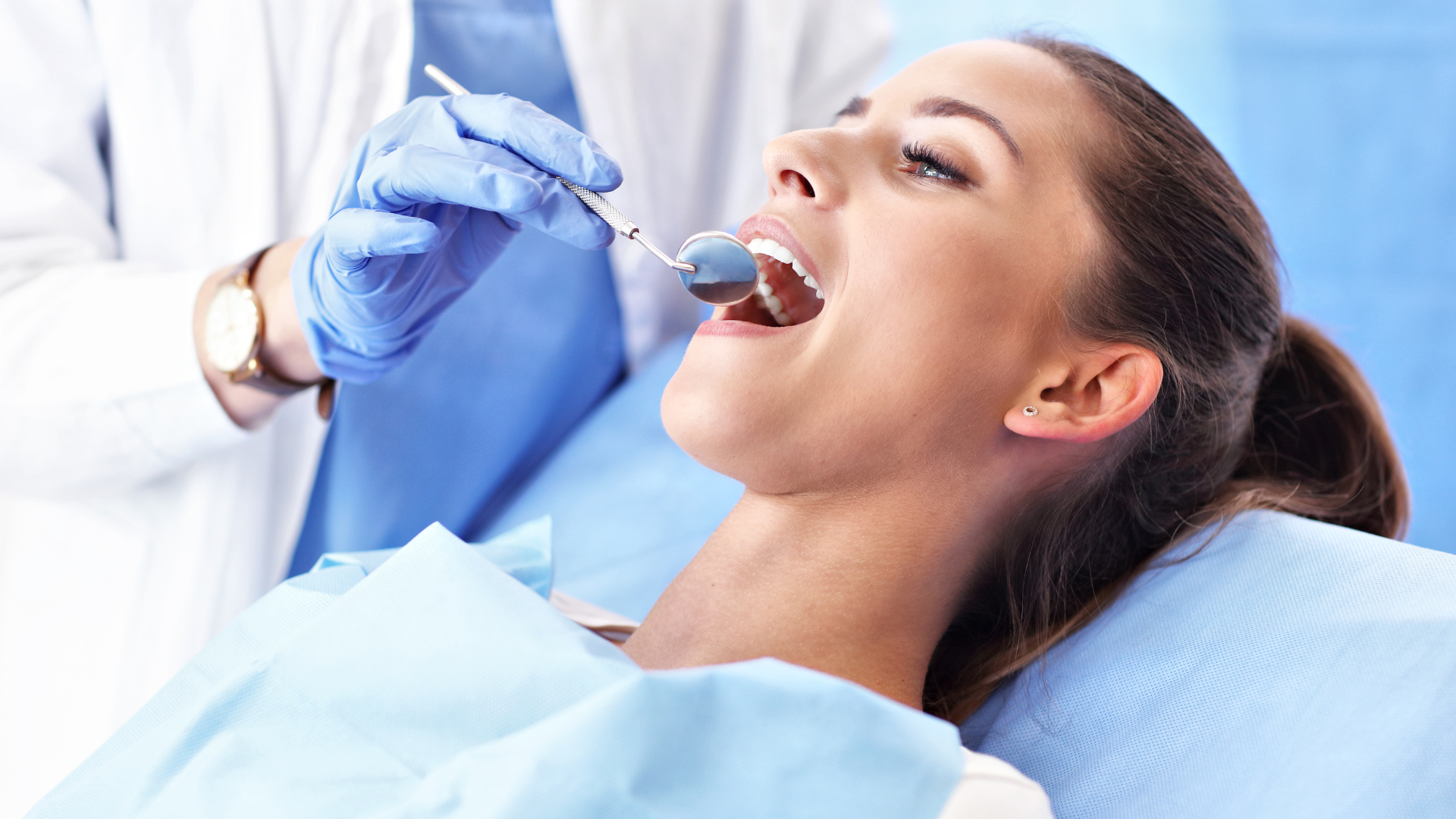 A woman is having her teeth examined by a dentist.