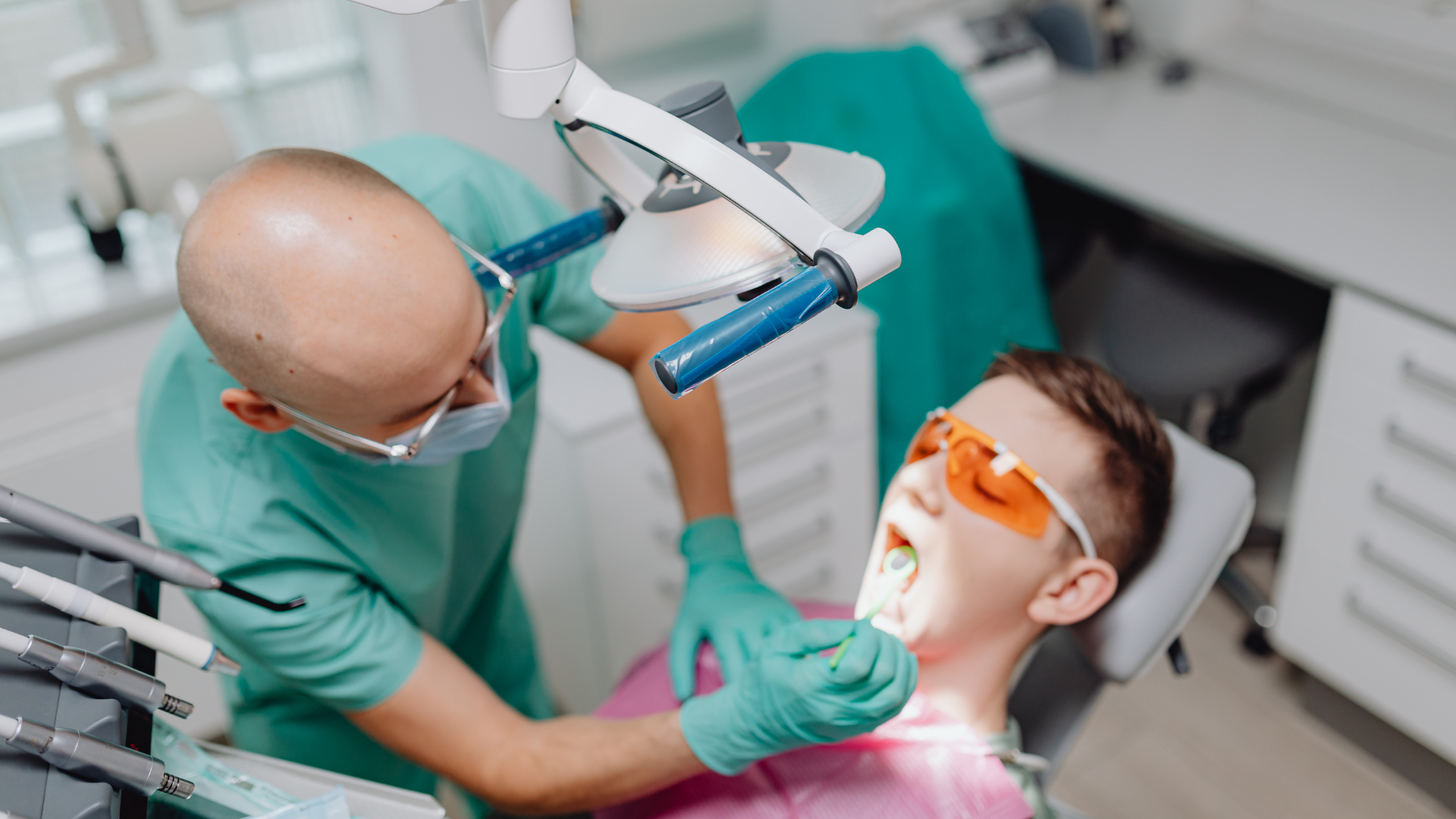 A dentist is examining a patient 's teeth in a dental office.