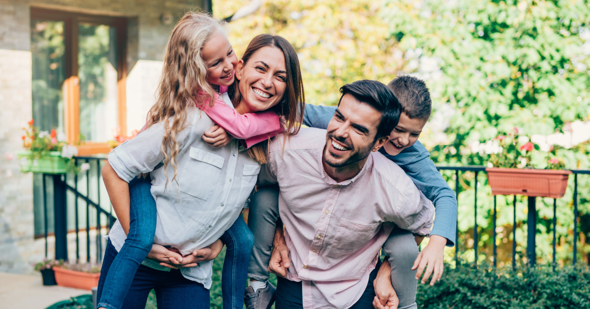 A family is posing for a picture in front of their house.