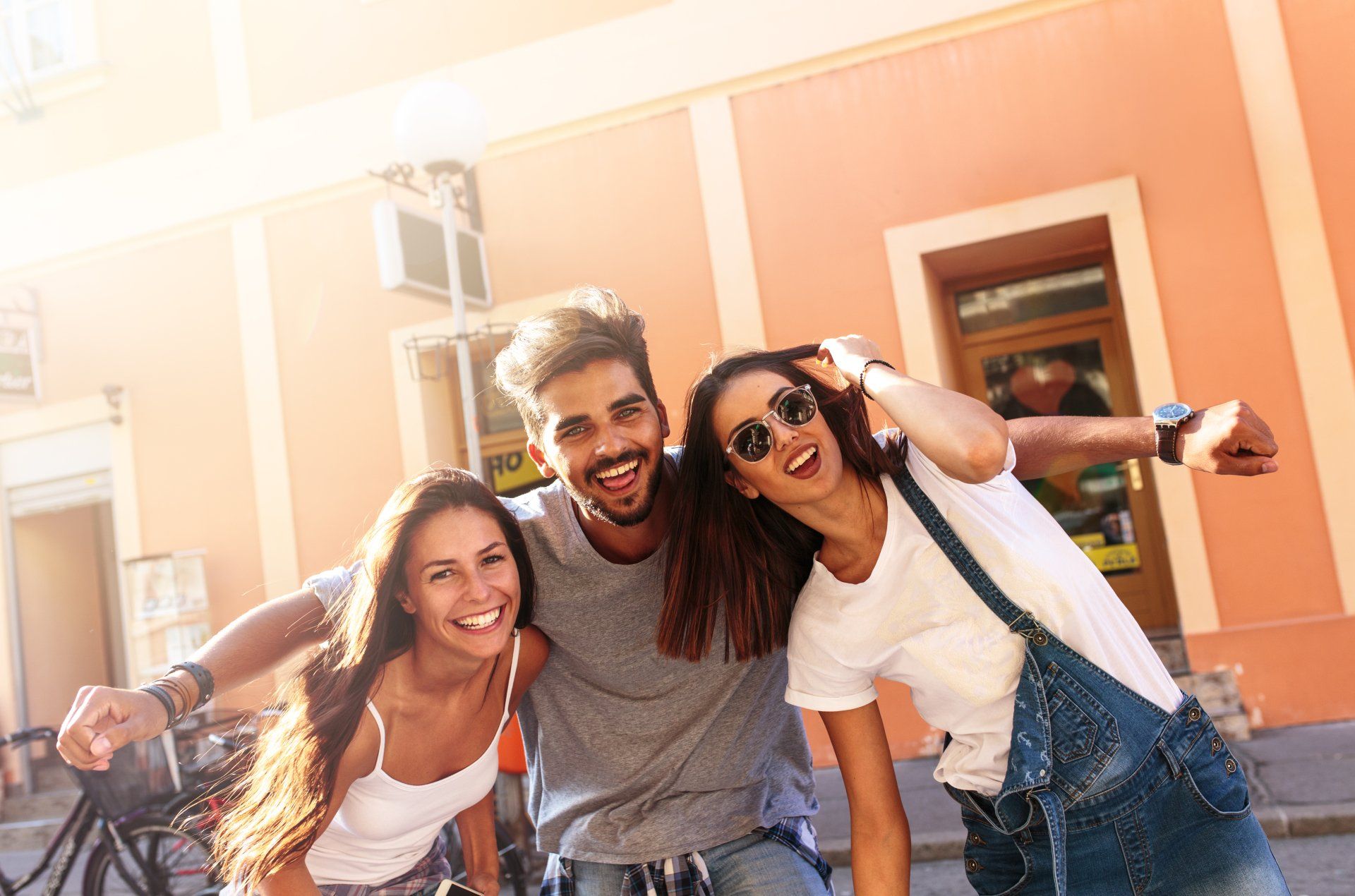 A group of young people are posing for a picture in front of a building.